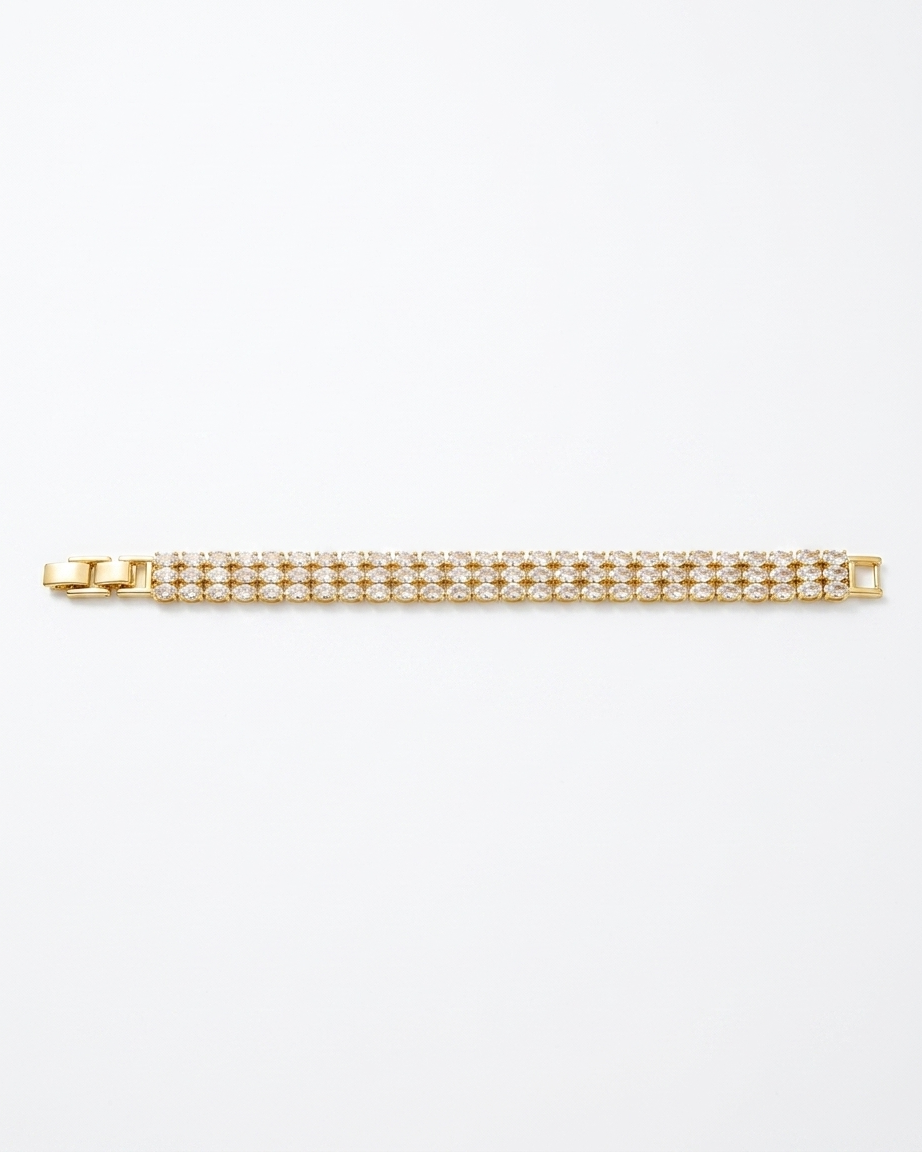 Gold bracelet with clear stones on a white background