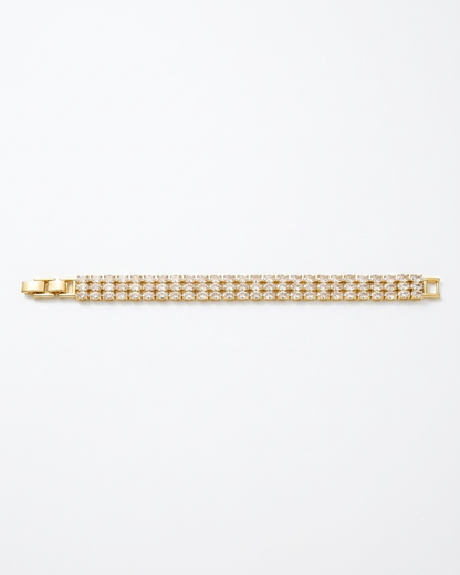 Gold bracelet with clear stones on a white background