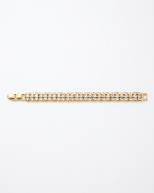 Gold bracelet with clear stones on a white background